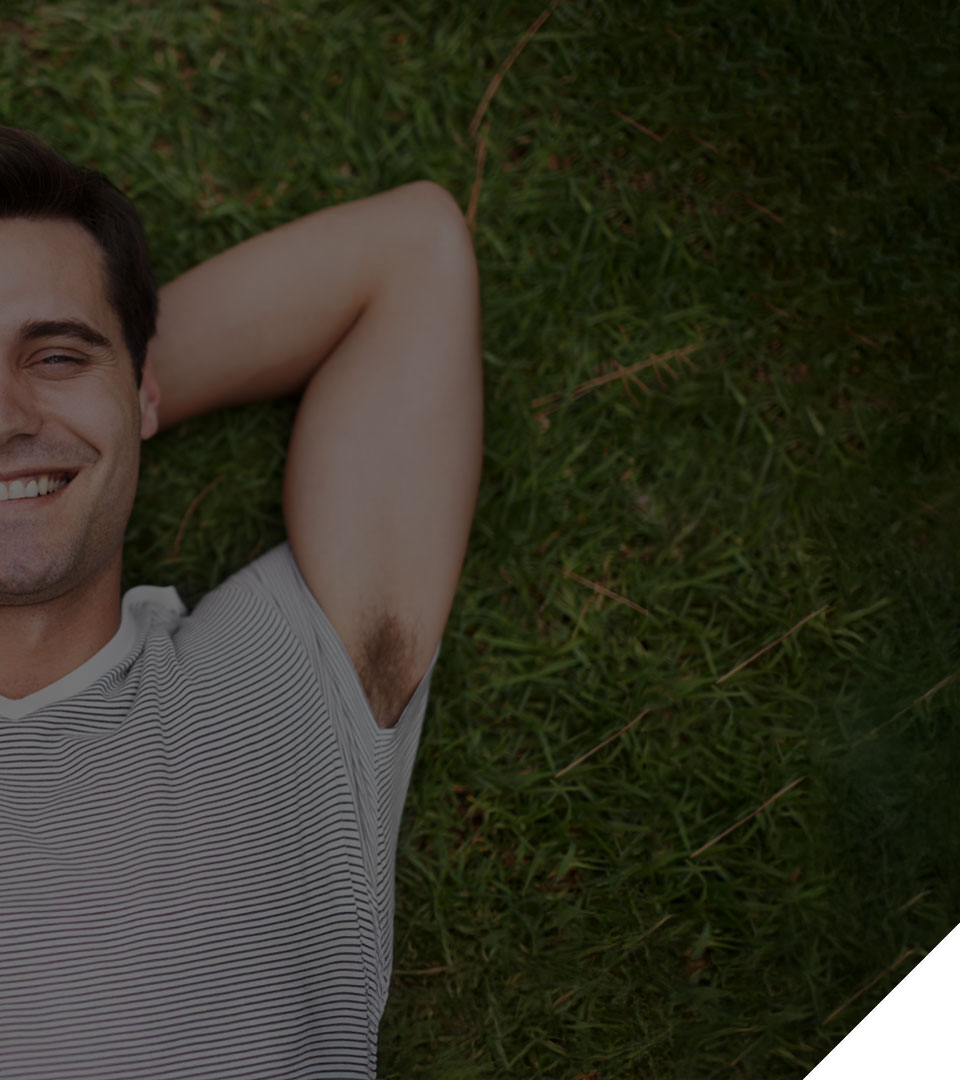 Smiling man lying back on grass looking relaxed