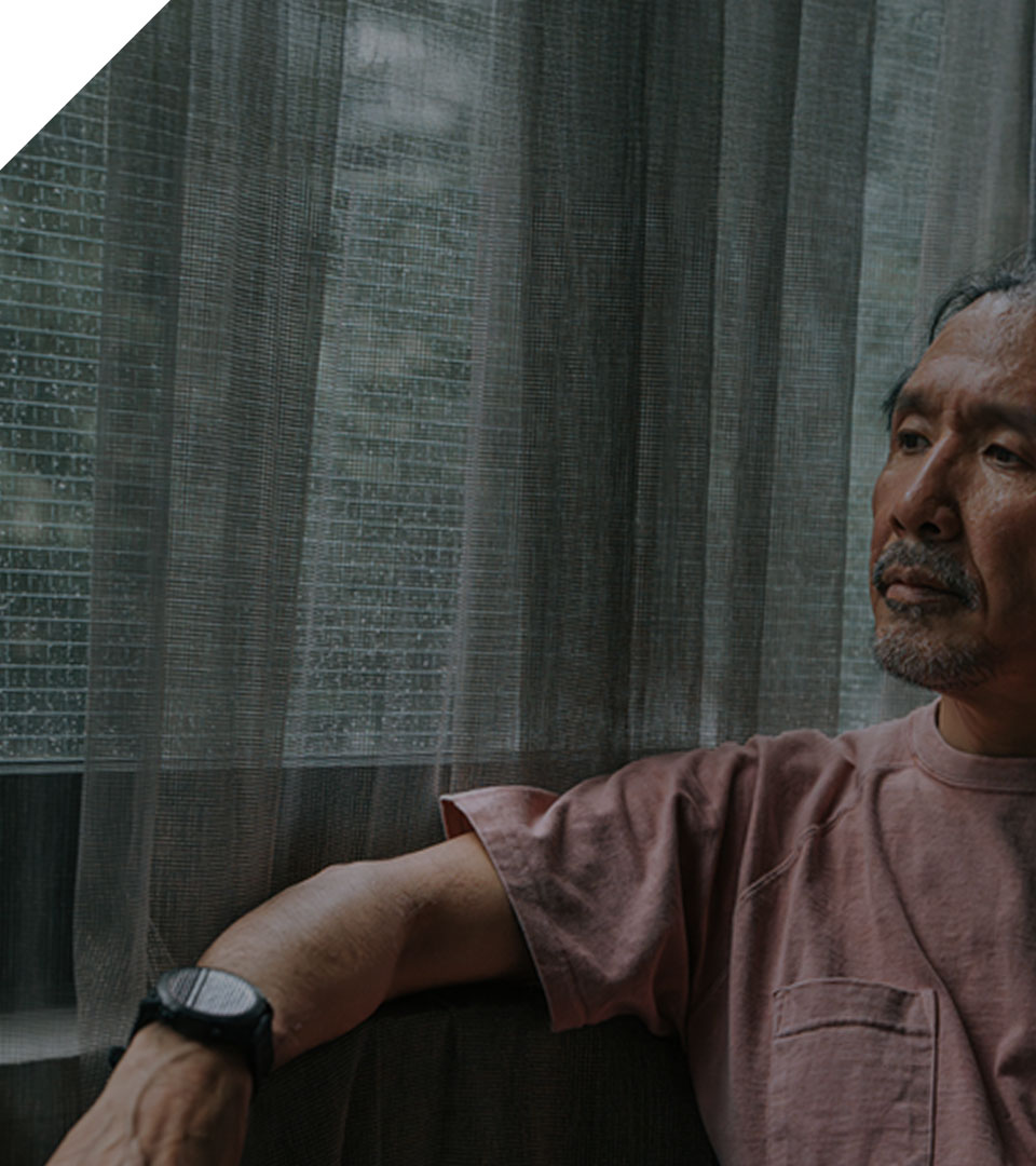 middle-aged man sitting alone looking out of the window